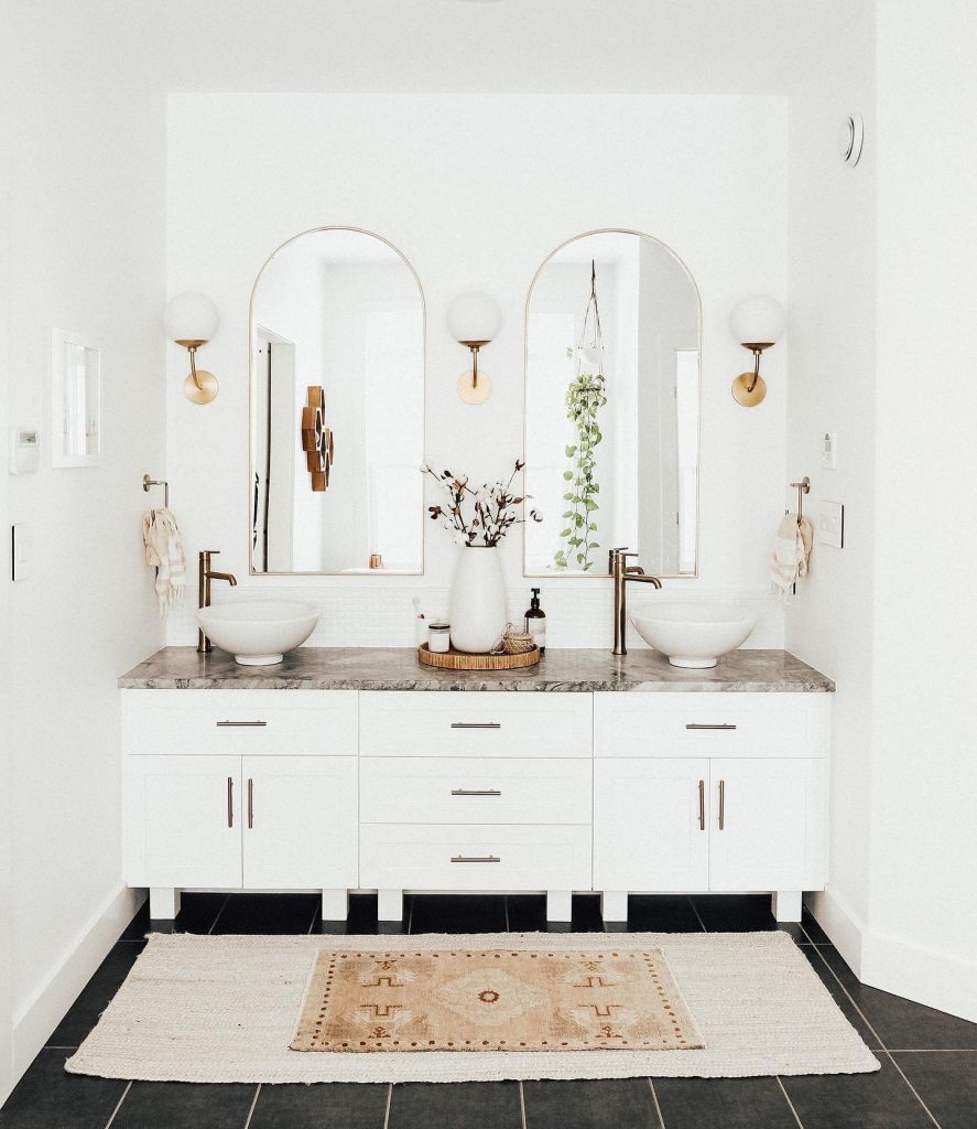 white bathroom with layered rugs
